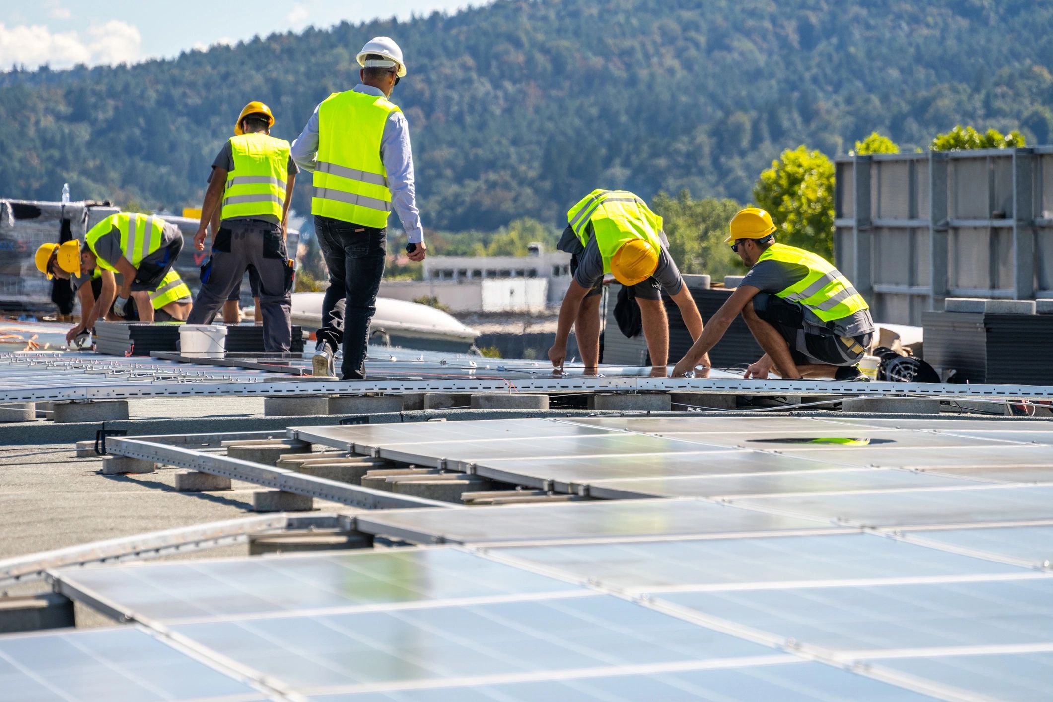 Technicians installing solar panels on a rooftop